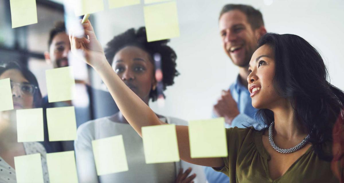 Manager working with team on a clear whiteboard planning