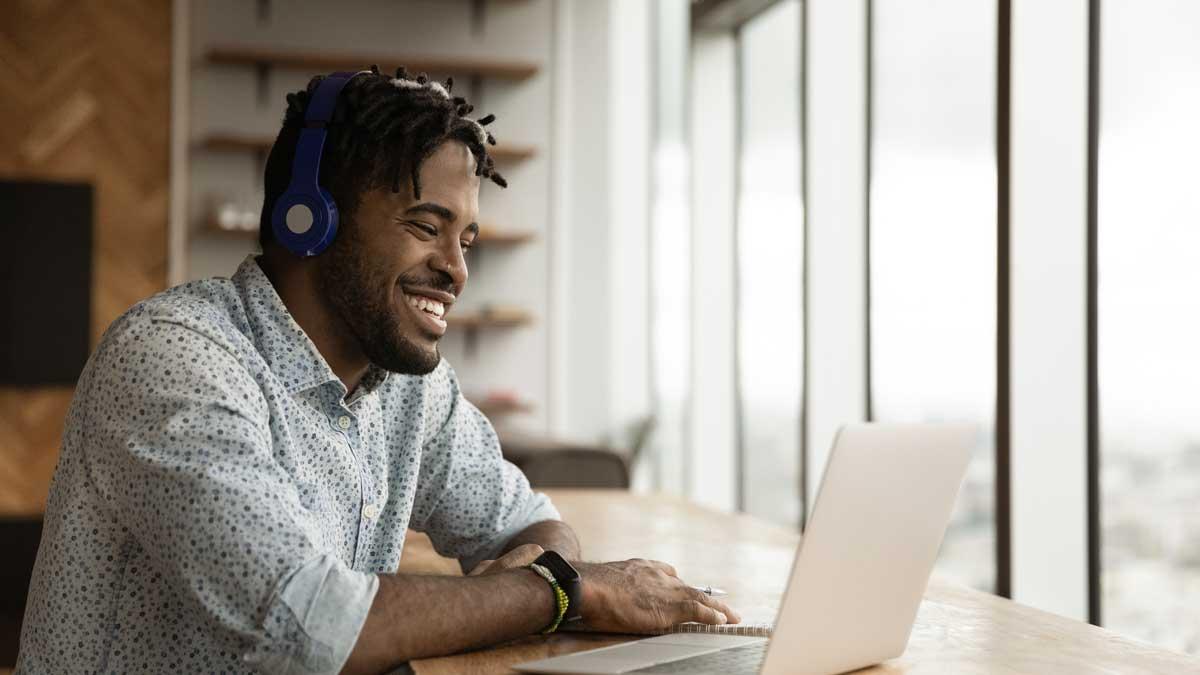 Student working on a laptop with headphones on