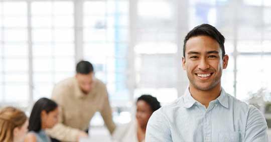 A leader in the boardroom facing away from a working group