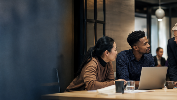 Employees collaborate during a team meeting in a modern office, representing teamwork, communication, and professional collaboration.